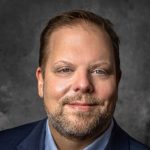 man in a suit and tie posing for a picture in a cloud supply chain context