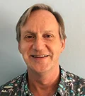 A Man In A Hawaiian Shirt Smiling At The Camera