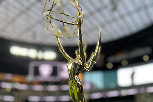 A Statue Of A Person Holding An Award In A Stadium At NAB 2024