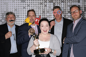 A Group Of People Standing Around Each Other Holding Trophies At NAB 2024