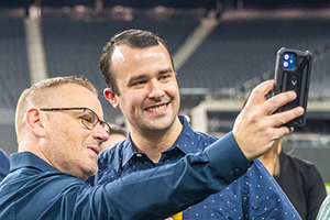 Two Men Capturing A Moment With A Smartphone At NAB 2024