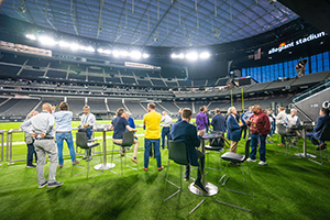 A Group Of People Standing On Top Of A Lush Green Field At NAB 2024