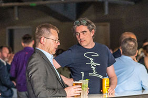 Two Men Enjoying Drinks At A Bar During NAB 2024