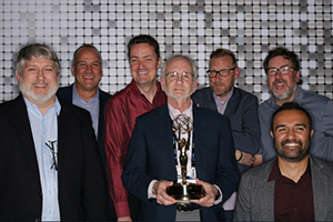 A Group Of Men Standing Next To Each Other Holding A Trophy At NAB 2024