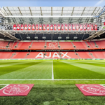 stadium with a green field and red seats