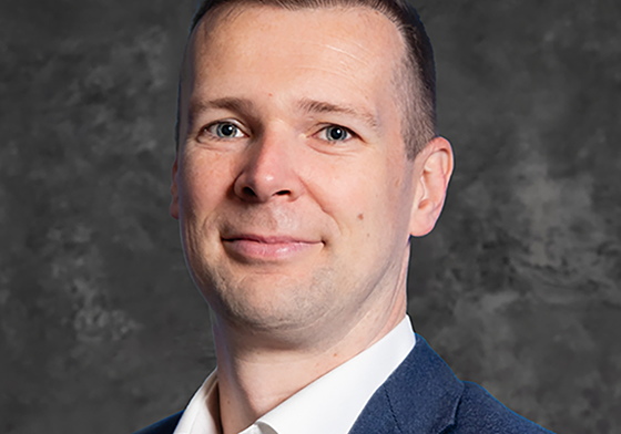 man in a suit and tie posing for a picture in a cloud supply chain context